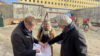 Statssekretær, byråd for byutvikling og prosjektleder fra Statsbygg ser på tegninger foran Oslo fengsel