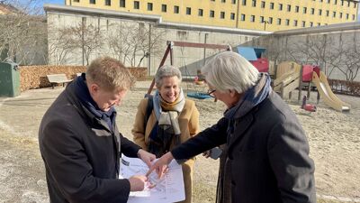 Statssekretær, byråd for byutvikling og prosjektleder fra Statsbygg ser på tegninger foran Oslo fengsel