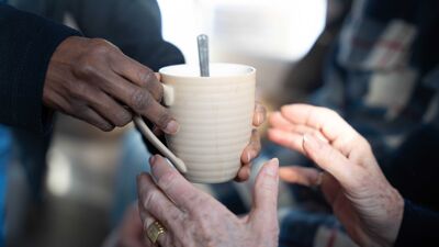 En person gir en kopp til en annen