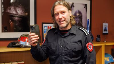 Brannmann som holder en mobiltelefon