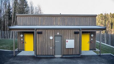 Bilde av en bolig med to gule dører og teknisk rom i midten. Boligen ligger på Ljabruveien 4 i Oslo.