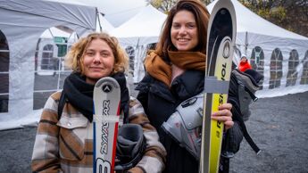 To damer viser frem skiene sine
