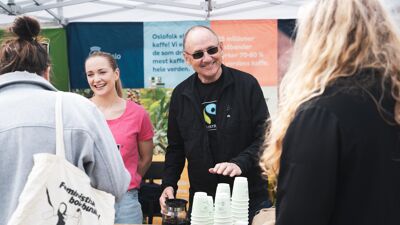 To personer deler ut Fairtrade-kaffe fra en stand under Vegetarfestivalen i Oslo i 2023.