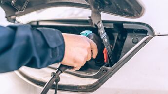 En hånd plugger inn en lader for en el-varebil.