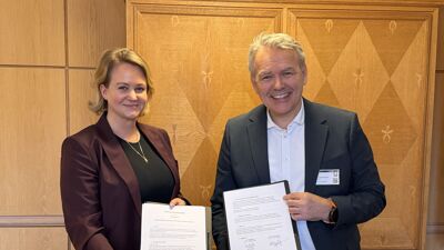 Byråd for sosiale tjenester Julianne Ferskaug (V) og husbankdirektør Jan Hjelle holder opp signerte dokumenter.