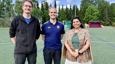 To menn og en kvinne på fotballbane.