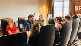 Møterom med ordfører, byrådsleder og byråd for sosiale tjenester med de internasjonale gjestene rundt bordet.