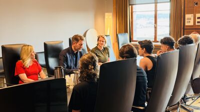 Møterom med ordfører, byrådsleder og byråd for sosiale tjenester med de internasjonale gjestene rundt bordet.