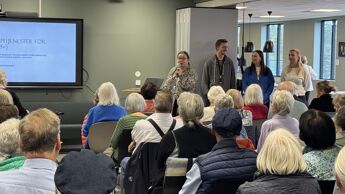 Fire personer står framme og presenterer for publikum