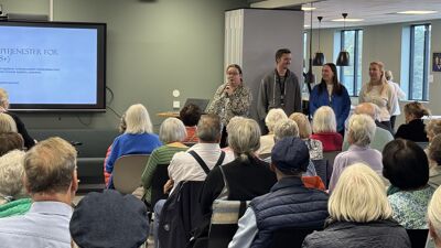 Fire personer står framme og presenterer for publikum