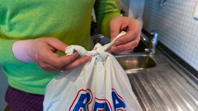 Nærbilde av to hender som knyter en rema-pose