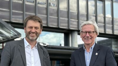 To byråder står og smiler foran høyblokka på Økern i Oslo