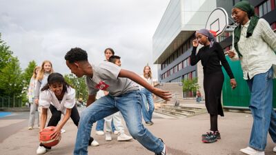 Skolebarn som spiller basket