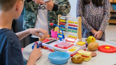 Skolebarn leker butikk i et klasserom.
