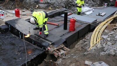 Arbeidere i gult refleksutstyr og hjelm.