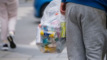 Mann i joggebukse samler pant på gata.