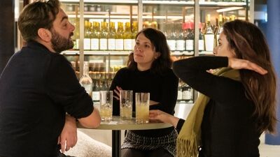 Tre personer sitter ved et bord på et skjenkested.