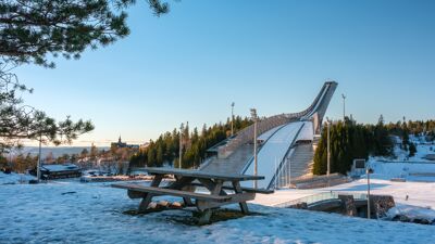 Bilde av Holmenkollen nasjonalanlegg i vinterdrakt på en solfylt dag.