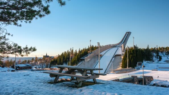 Bilde av Holmenkollen nasjonalanlegg i vinterdrakt på en solfylt dag.