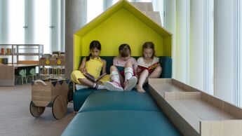 Barneavdelingen på biblioteket, barn sitter og leser inne i et lite hus.