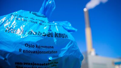 Blå plastpose foran fabrikkpipe