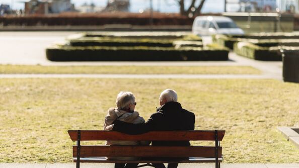 Senior-par på benk i park