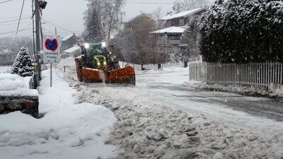 Traktor som brøyter i en gate.