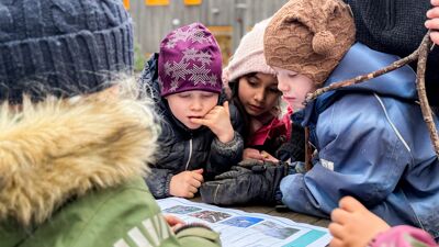 bilde av barn som leser rundt et bord