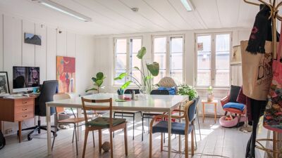 Kontorlokale med bord i midten og stoler rundt. Store vinduer med fint lys.