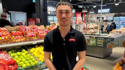 John poserer i butikken han er ansatt i.