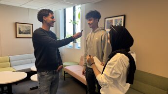 Tre ungdommer står oppreist. En blir intervjuet av de to andre.