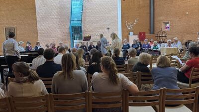 Korister og konsertpublikum inne i Holmlia Kirke.