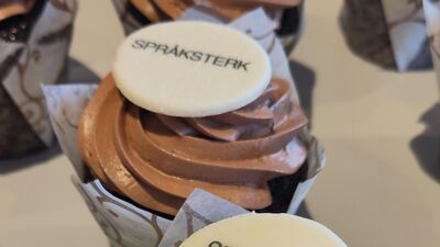 En muffins med dekorasjon som sier Språksterk