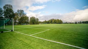Fotballmål og grønt gress på fotballbane.