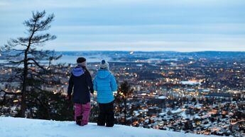 To barn i vinterklær ser ut over Oslo by