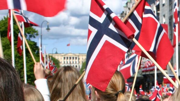 Norske flagg og barn i barnetoget på 17. mai.