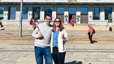 Einar Rydal og Lene Malerud står utenfor Oslo rådhus med norske flagg.