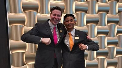 To unge gutter i dress smiler og holder knyttneve mot hverandre