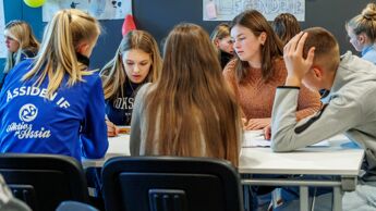 Ungdommer som sitter rundt en pult.