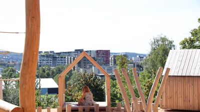 En elev som sitter i en skolegård med Oslo i bakgrunn.