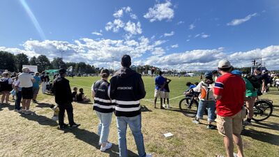 To personer med jakker med tekst Utekontakt sett bakfra, ser ut over Ekebergsletta på Norway cup
