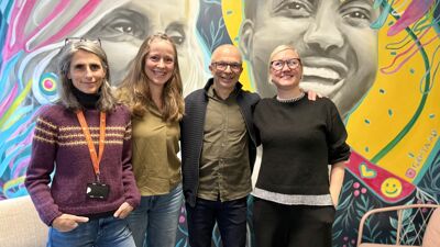 Fire personer, tre kvinner og en mann for et fargerikt veggmaleri.