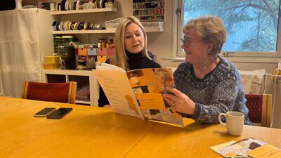 To kvinner blar i veilederen Digital trygghet-en veileder for eldre i en digital hverdag