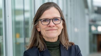 Kvinne i 50 årene med briller og et lite smil