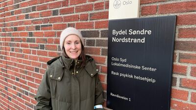 Vi ser en jente ved siden av et skilt