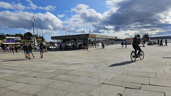 Fisketorget i bakgrunn med mennesker som ferdes rundt.