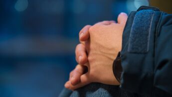 Person som folder hendene sett i fra siden