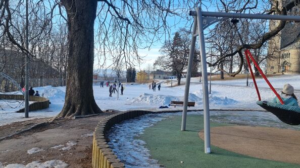 Skøyteisen i Vålerengaparken med lekestativ i forgrunnen