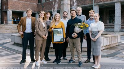 Ansatte i Resirqel og byråd for miljø og samferdsel, Sirin Stav, med blomster og diplom foran Oslo rådhus
