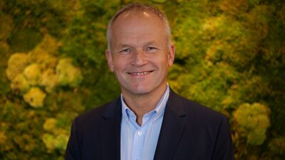Mann foran vegg av planter